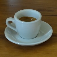 An espresso, made by my Rancilio Silvia espresso machine, in a classic white cup and saucer from Acme &amp; Co., New Zealand, distributed in the UK by Caravan Roastery.