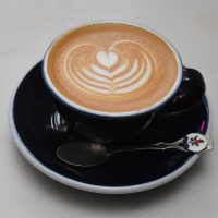 A classic flat white with some lovely latte art, served in a classic black cup at The Eclectic Collection.