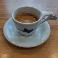 A classic espresso in a white espresso cup with an outline image of the State of Texas on the side.