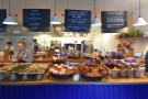 The counter runs the full width of the store, menu and information boards hanging above.