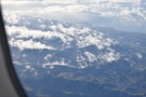 ... flying over the cloud-wreathed mountains which were now far below.