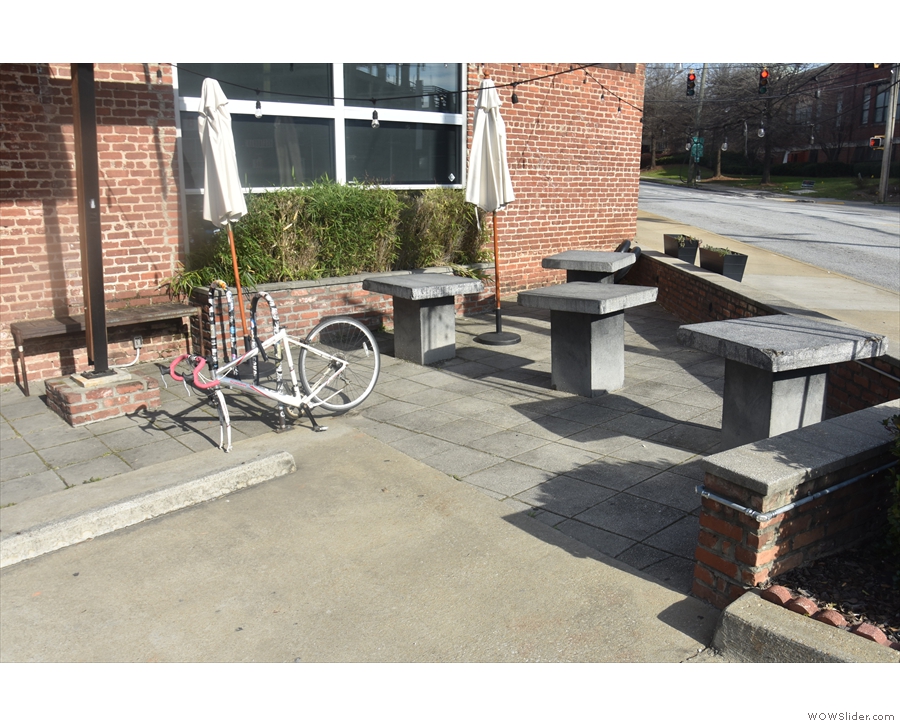 ... and a small, wedge-shaped outdoor seating area with four concrete tables beyond that.