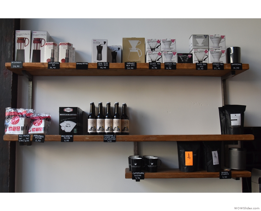 The short left-hand wall holds the retail shelves with coffee kit and bags of coffee.